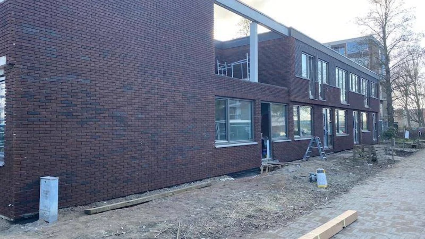 Nieuwbouwwoningen in Utrecht met een gevel van donkerrode steenstrips en grote raampartijen