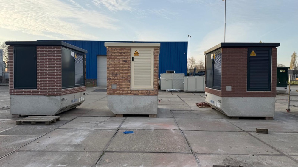 Meerdere trafostations met steenstrips in verschillende kleuren op het terrein in Almere