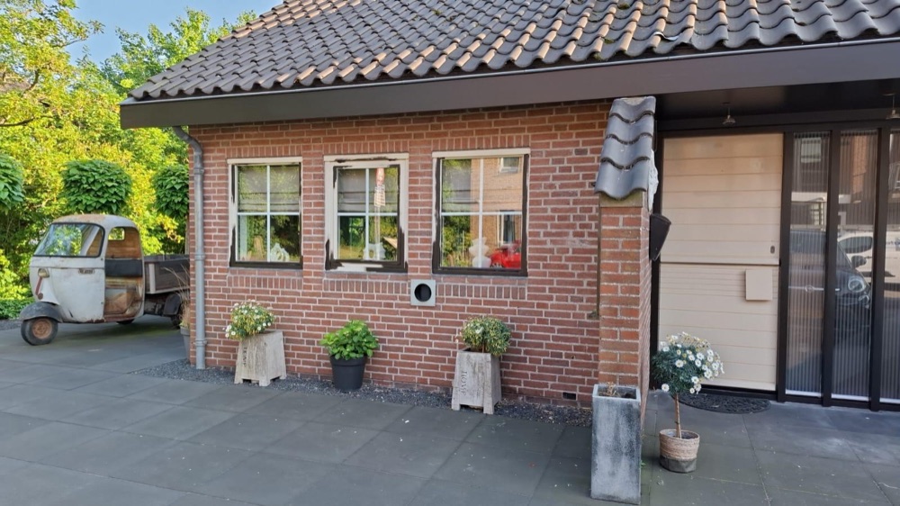 Villa in Koedijk vóór het werk, met een gevel van rode baksteen en witte kozijnen