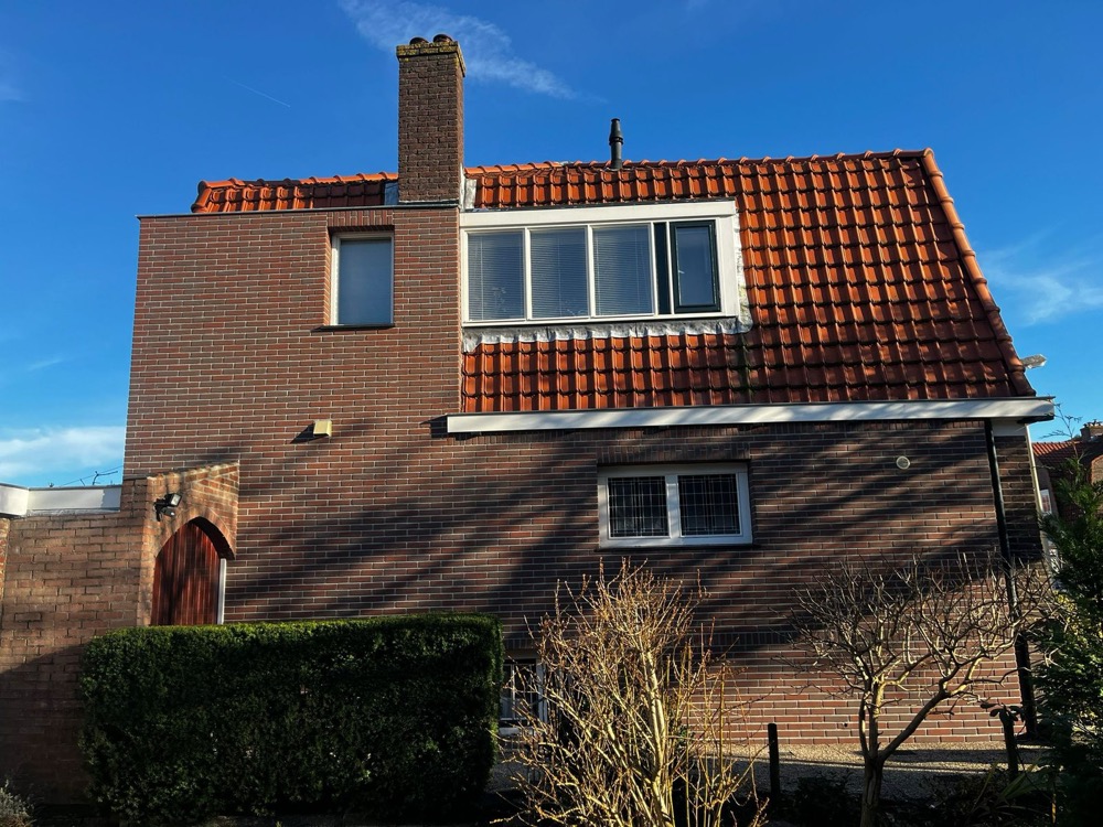 Dezelfde kopgevel in Bussum na de werkzaamheden: geïsoleerd en afgewerkt met minerale steenstrips