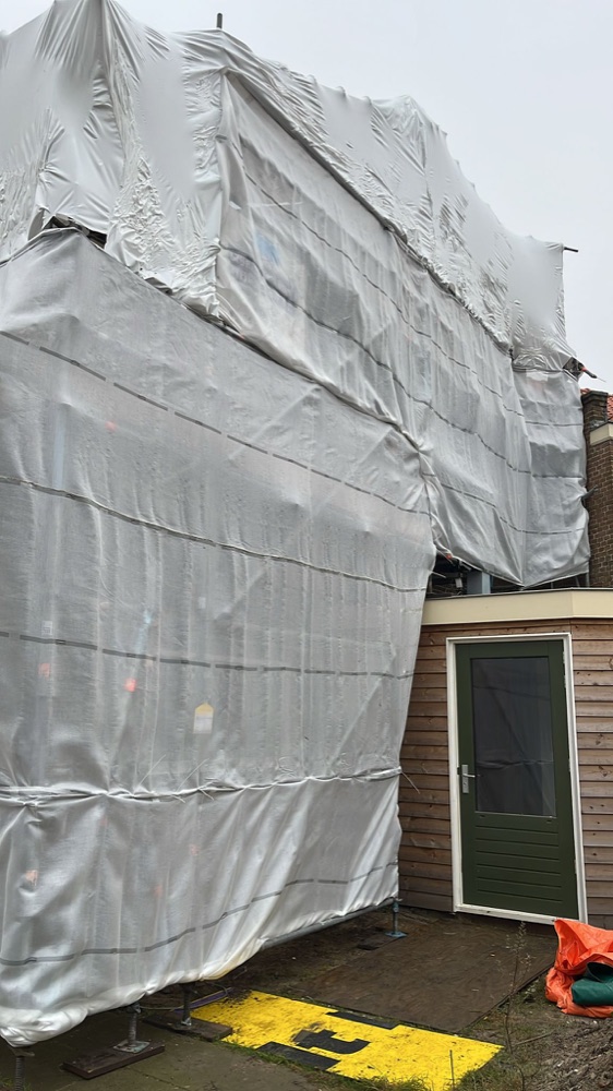 Woonhuis in Haarlem ingepakt in een steiger met regenkap tijdens het werk